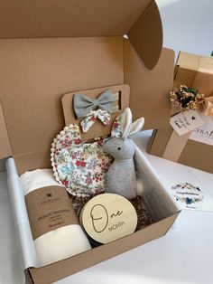 an open box with stuffed animals and other items in it on a white table top