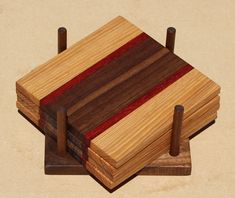 three wooden coasters stacked on top of each other with red and brown strips in them