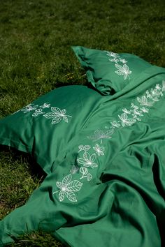 a green blanket laying on top of a lush green field