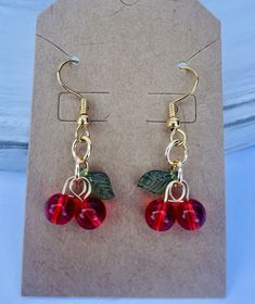 Red Cherry Earrings ! Great find and affordable for a special gift or to treat yourself . Earrings length is a little over 1.5 inches . Cherries are too cute ! Appropriate for any age . Small red cherries 6mm with green leaf hanging from goldtone fish hook ear wires .  Thanks for stopping by . Please come again for holiday shopping, desks and free shipping over $35 order  . New listings coming at all times ! Diy Jewlery, Cherry Earrings, Red Cherry, Holiday Shopping, Green Leaf, Diy Accessories, Leaf Earrings, Fish Hook, Cute Earrings