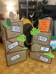 three cardboard boxes with plants on them sitting on the floor in front of a couch