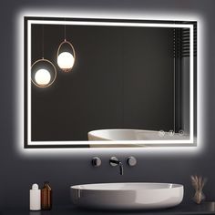 a bathroom with a sink, mirror and lights on the wall above it's counter