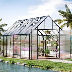 a small greenhouse with lots of plants and flowers in the house, next to a body of water