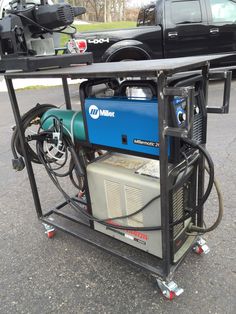 an air compressor sitting on top of a cart in the middle of a parking lot