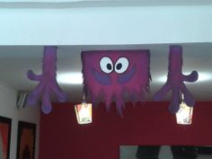 two lights that are on the ceiling above a room with red walls and purple decorations