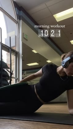 a woman in black shirt and headphones laying on floor next to exercise mat with text reading morning workout 1011