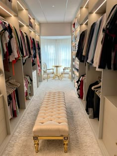 a walk - in closet with white carpeting and lots of clothes