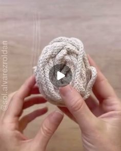 someone is holding a knitted object in their hands, with the video below it