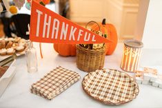 a table topped with plates and napkins next to a sign that says thank you