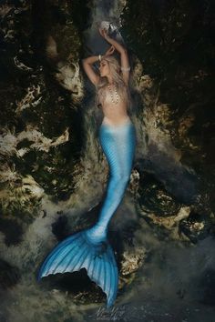 a woman is floating in the water with a mermaid tail