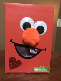 the sesame street book has an orange face with big eyes and a heart on it