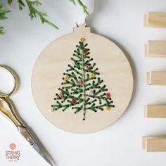 a wooden ornament with a christmas tree on it next to some wood pegs