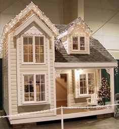 a doll house with christmas lights on the roof