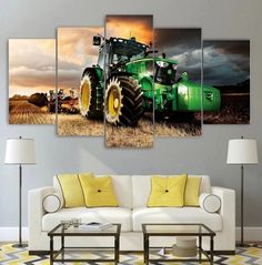 a large green tractor in the middle of a field with storm clouds above it on a cloudy