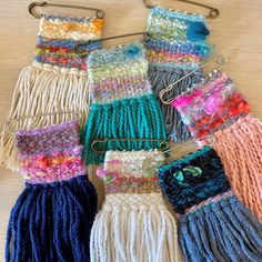 there are many crocheted items hanging on the clothes pegs and they are all different colors