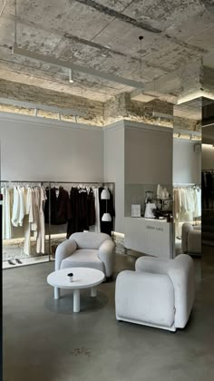 an open store with white furniture and clothes on hangers