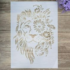 a paper cut with a lion's head and flowers on it next to purple flowers