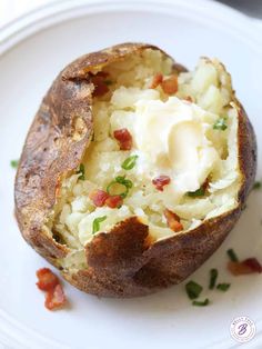 a baked potato on a white plate with bacon