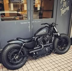 a black motorcycle parked in front of a building