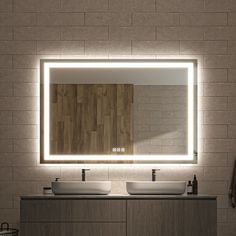 a bathroom with two sinks and a large mirror above it that is illuminated by lights