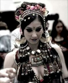 a woman wearing an elaborate headdress while holding a cell phone in her hand