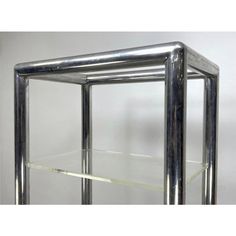 a metal shelf with glass shelves on each side and one shelf below it, in the shape of a rectangle