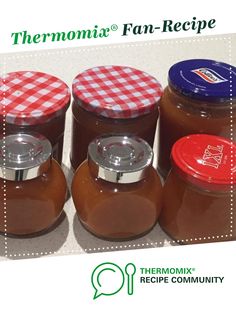 thermomi jars are lined up in a row with their lids down and checkered tablecloth on them