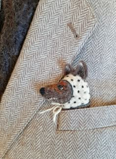 a small stuffed animal in the pocket of a jacket