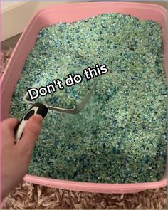 someone is using a spoon to scoop something out of a pink litter box with the words don't do this on it