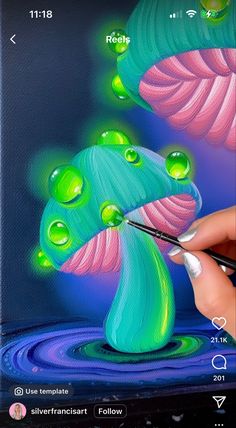 a person is painting a flower with water drops on the screen and using a brush to draw it