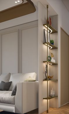 a white couch sitting next to a tall shelf filled with books on top of a hard wood floor