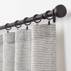 black and white curtains hanging on the side of a curtain rod in front of a window