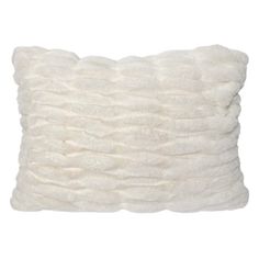 a white pillow that is made out of fluffy fur and sits on a white surface