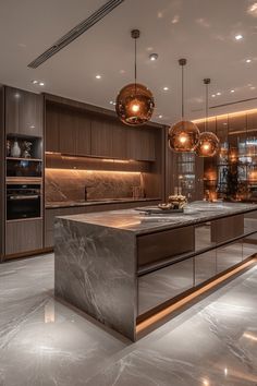 an elegant kitchen with marble counter tops and stainless steel appliances is lit by pendant lights