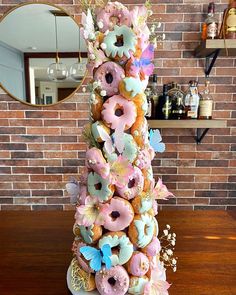 there is a very tall cake made out of donuts and flowers on the table