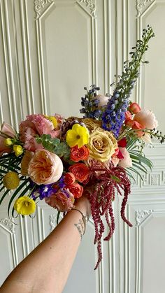 a person holding a bouquet of flowers in their hand