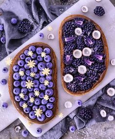 two slices of bread with blueberries and other toppings on them sitting next to each other