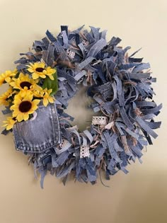 a blue jean wreath with sunflowers and diced up jeans hanging on the wall