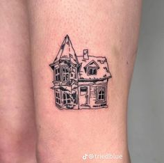 a black and white drawing of a house on the side of a woman's leg