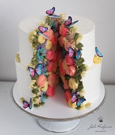 the cake is decorated with butterflies and flowers