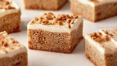 several pieces of cake with white frosting and nuts on top