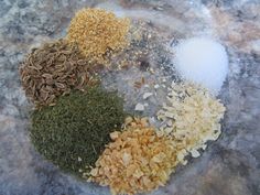 four different types of spices on a marble counter top, including ground flakes and seasonings