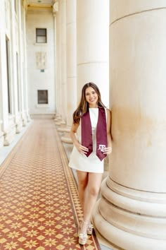 a woman leaning against a pillar wearing a purple scarf