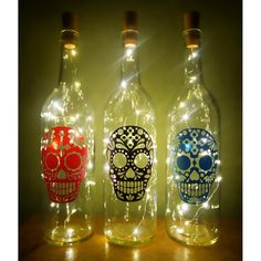 three bottles that have lights in them with skulls on them