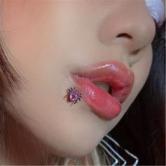 a close up of a woman's nose with a pink lip and piercing on it