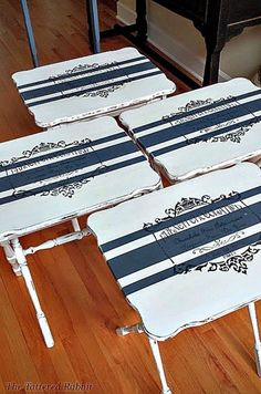 four tables with black and white stripes on them sitting on the floor in front of a piano