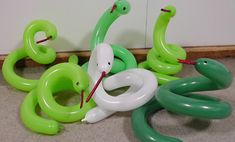 some green and white balloons are laying on the floor next to each other in front of a wall