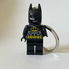 a lego batman keychain is shown on a white surface with a black and yellow logo