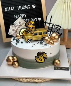 a white and gold birthday cake with money on top