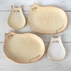 four ceramic plates with cats sitting on them